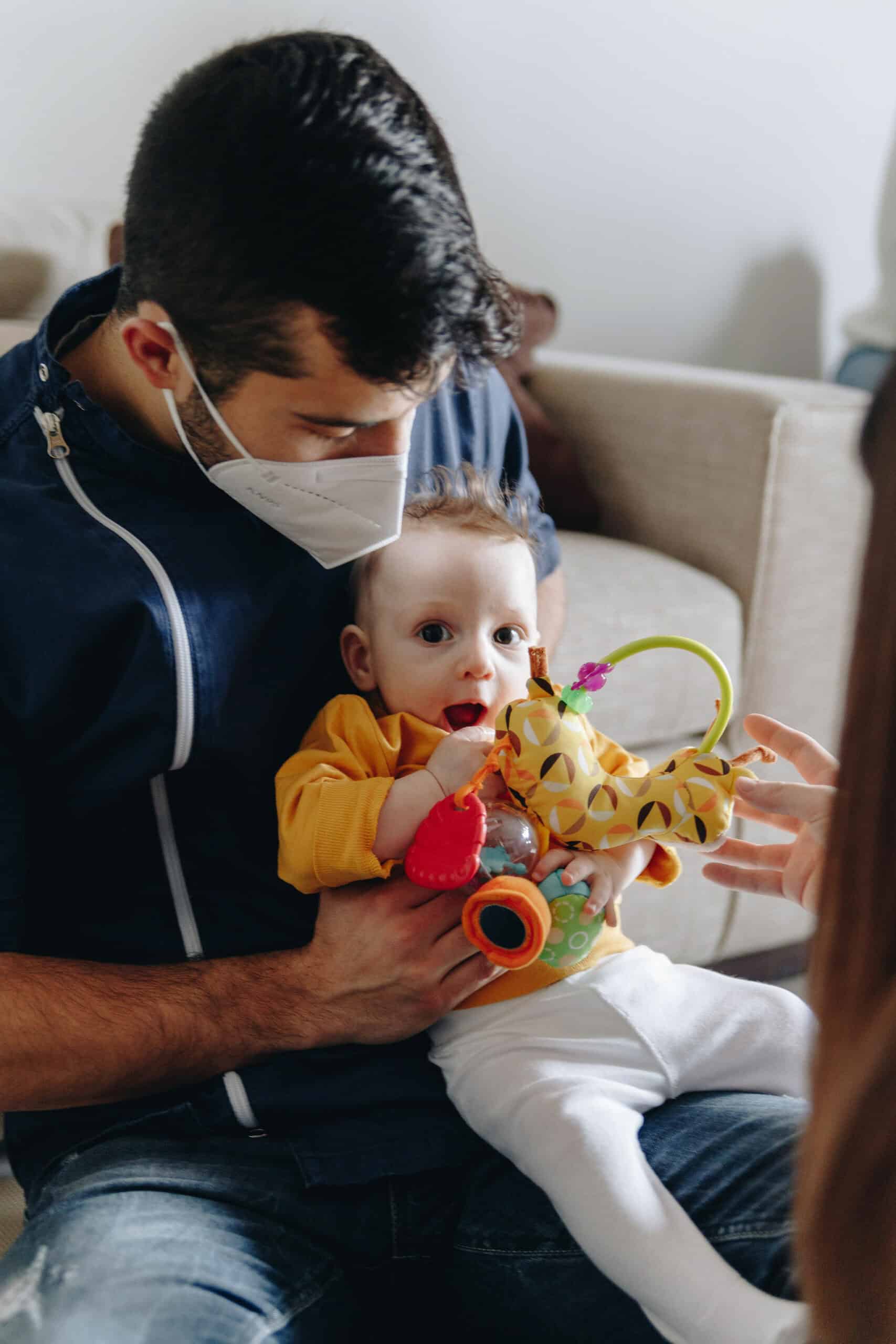 Foto di Lorenzo mentre tiene in braccio un neonato e lo visita