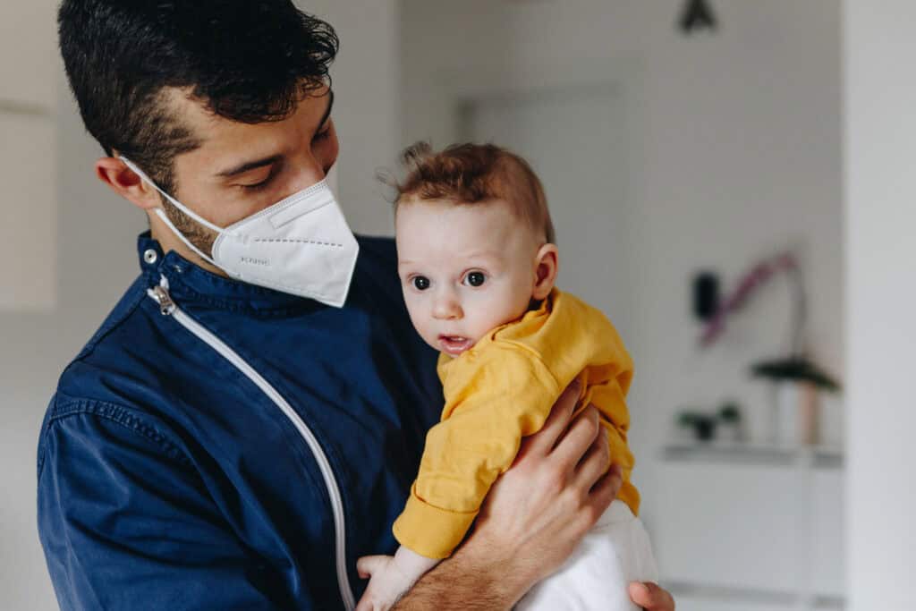 Foto di Lorenzo mentre tiene in braccio e guarda un bimbo