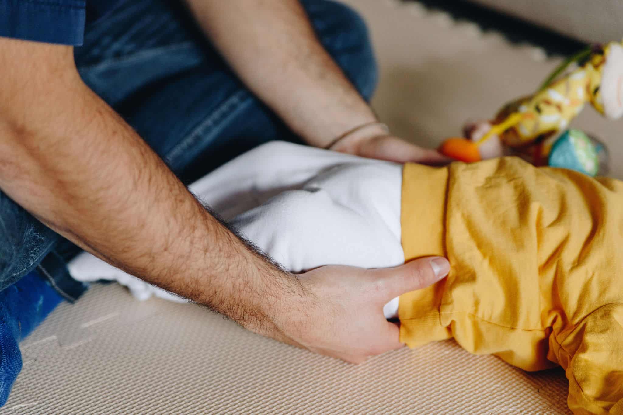 Foto delle mani di Lorenzo, durante un trattamento di osteopatia su un neonato