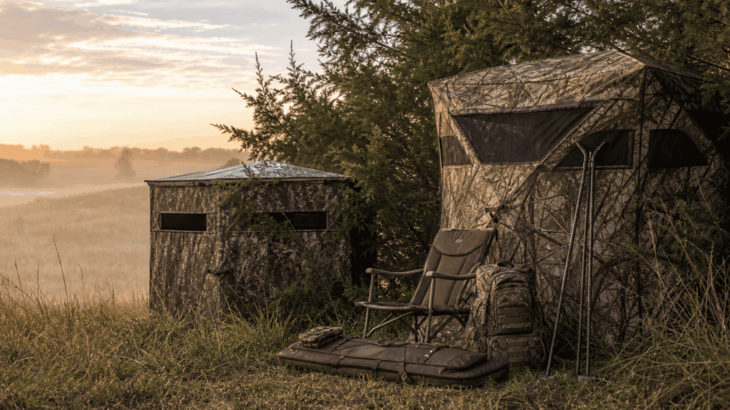 Brushed-in hunting ground blind with chair and shooting support at a field edge
