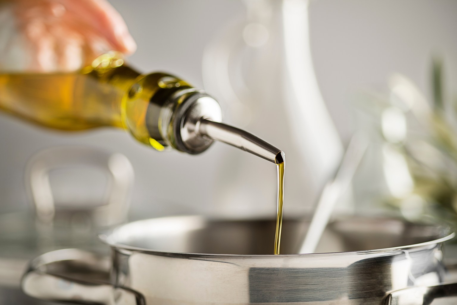 Olive oil being poured into a pot during cooking