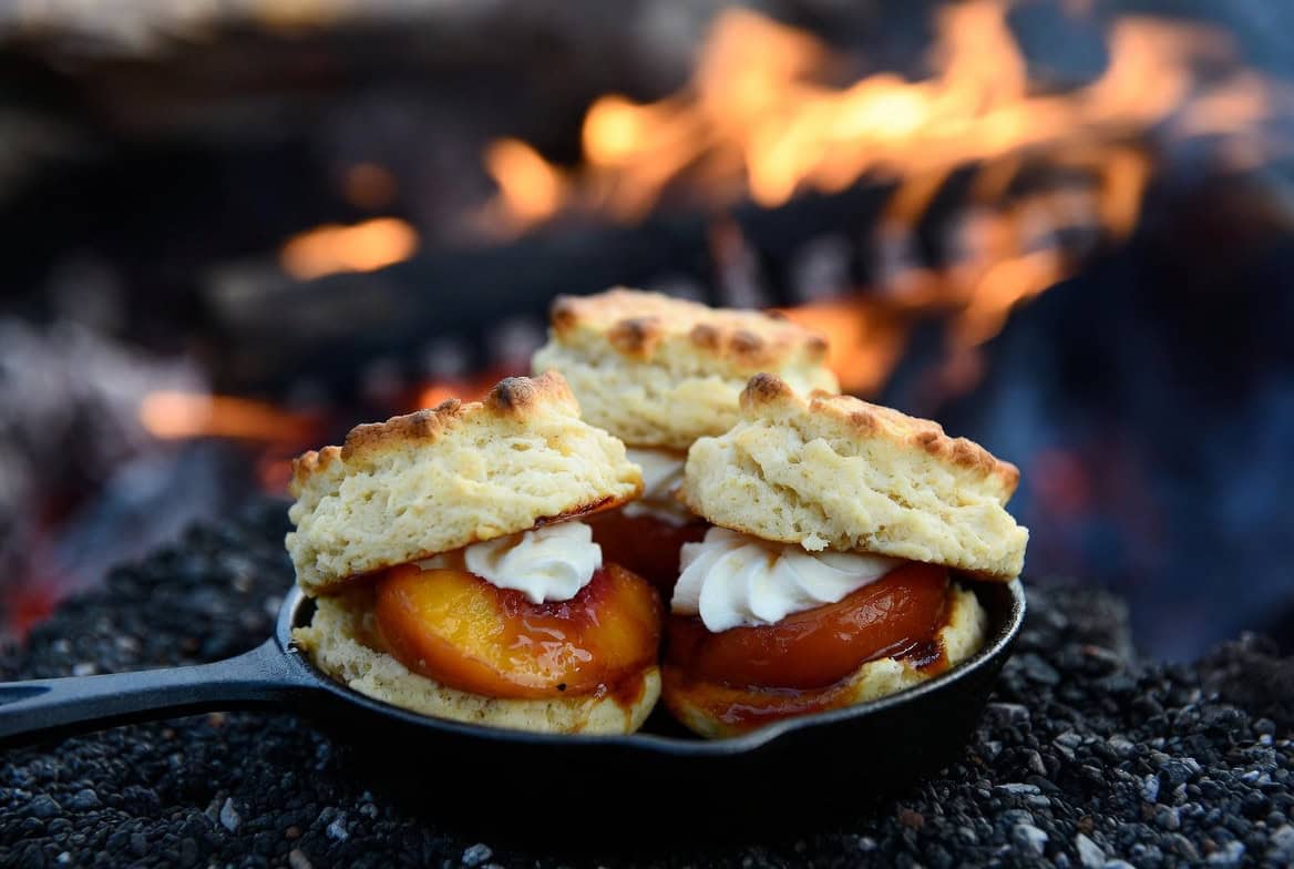 Peach shortcakes with biscuits cream and caramelized peaches by campfire