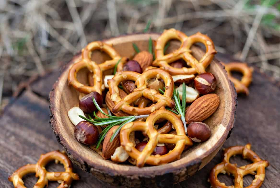 Maple-glazed pretzels, nuts, and rosemary trail mix in wooden bowl
