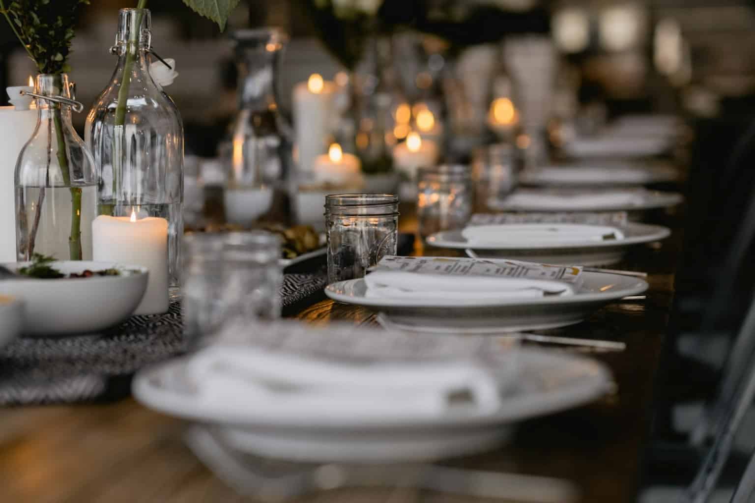 Set dinner table with plates and glassware, host-ready service