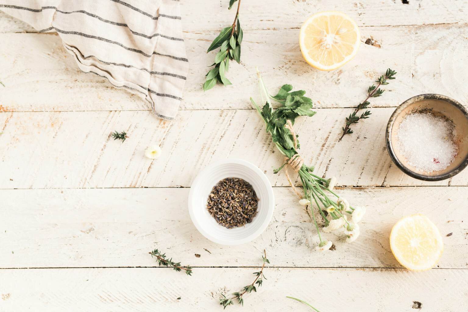 Kitchen prep with lemons, herbs, and ingredients used to adjust seasoning and flavor