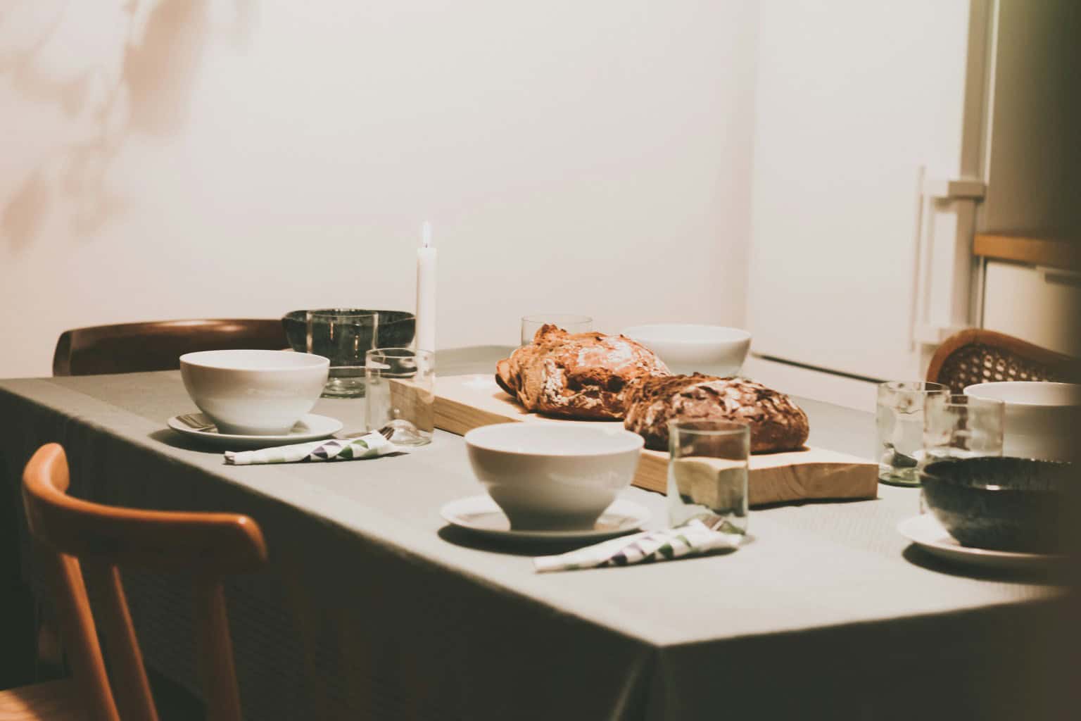 Dining room service surface with serving dishes and place settings ready for paced dinner service