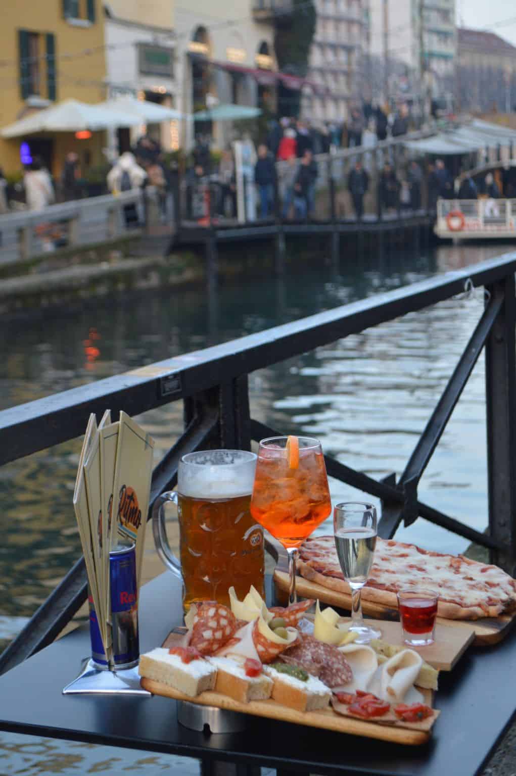 Italian-style aperitivo table with spritzes and small savory snacks arranged for a light pre-dinner gathering