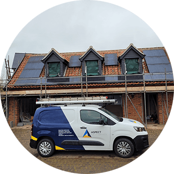 a van parked in front of a house with solar panels on the roof.