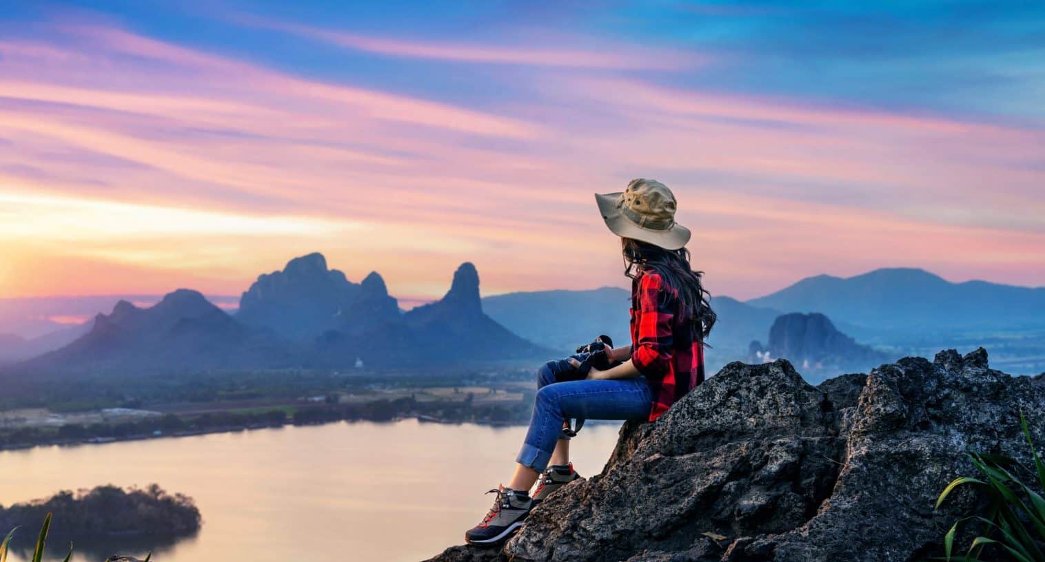 Tourist sitting on Phu sub lek viewpoint at sunset, Lopburi, Thailand.