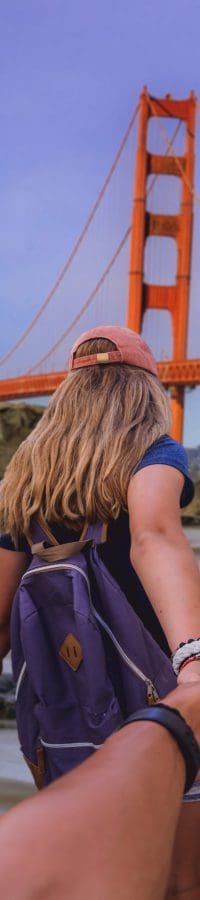 vertical-shot-woman-holding-man-s-hand-leading-him-golden-gate-bridge