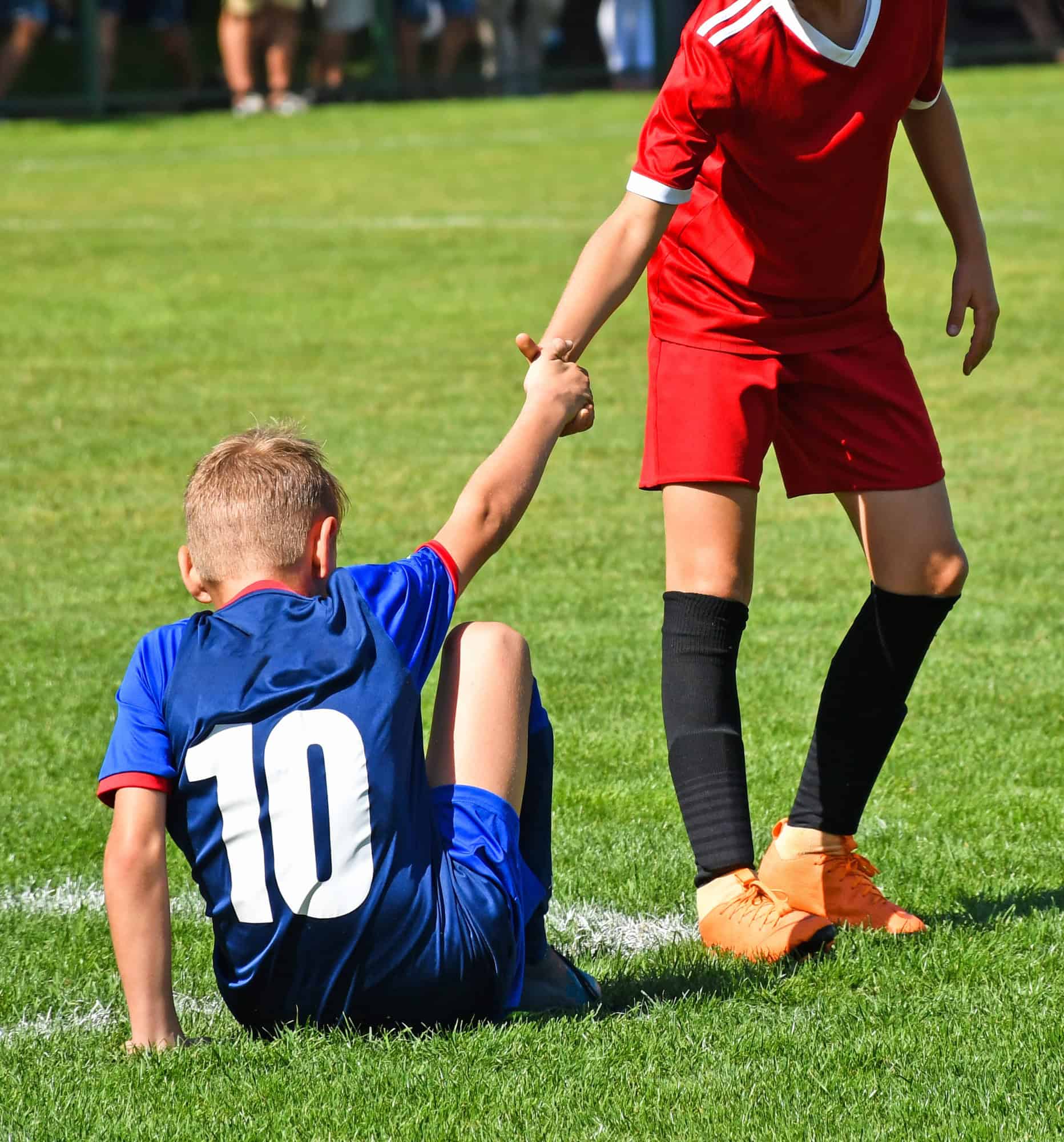 Young kid soccer player helps on the field Empathy through youth sports