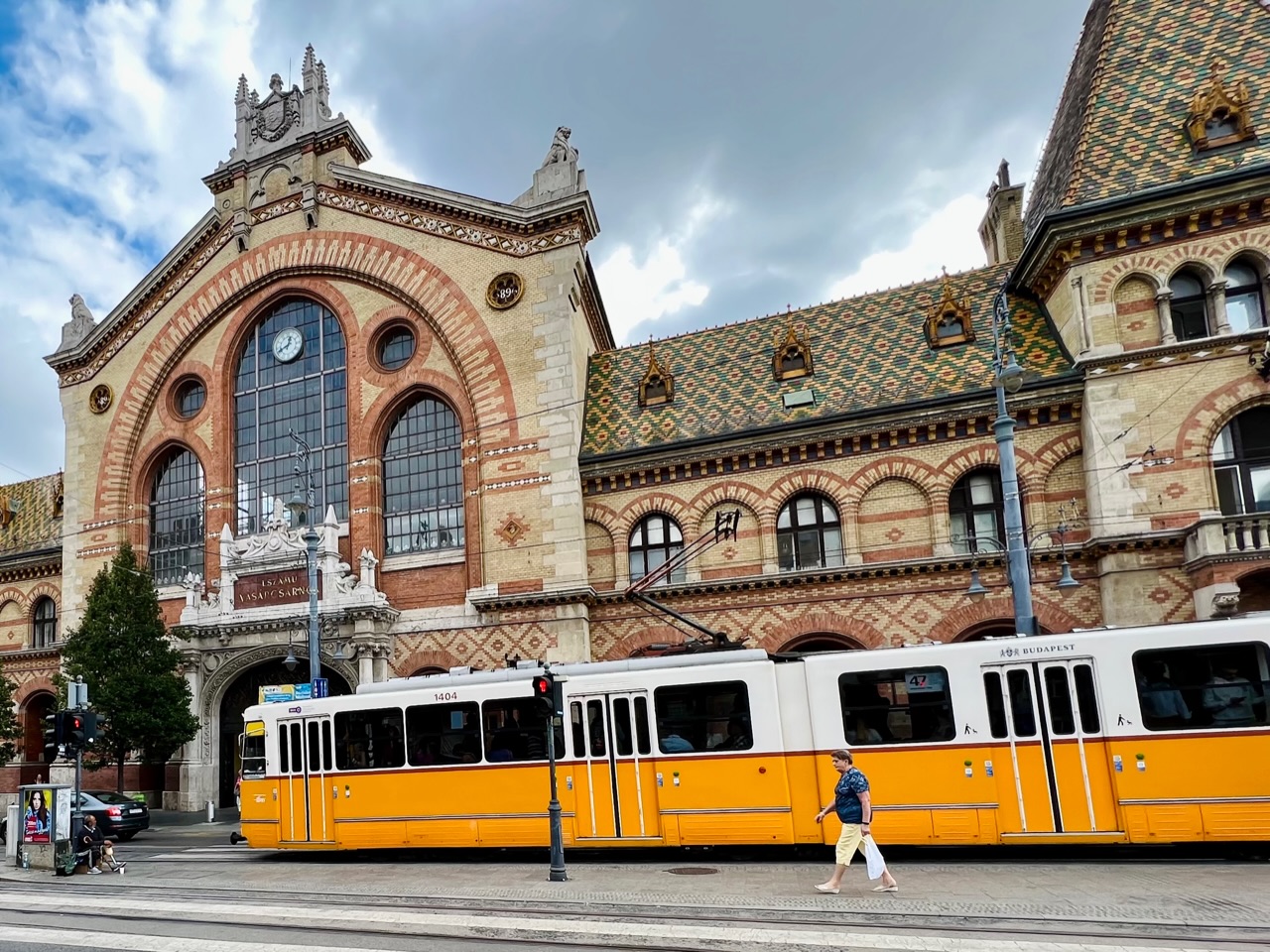 The exterior of Budapest's Great Market Hall with a yellow tram in front