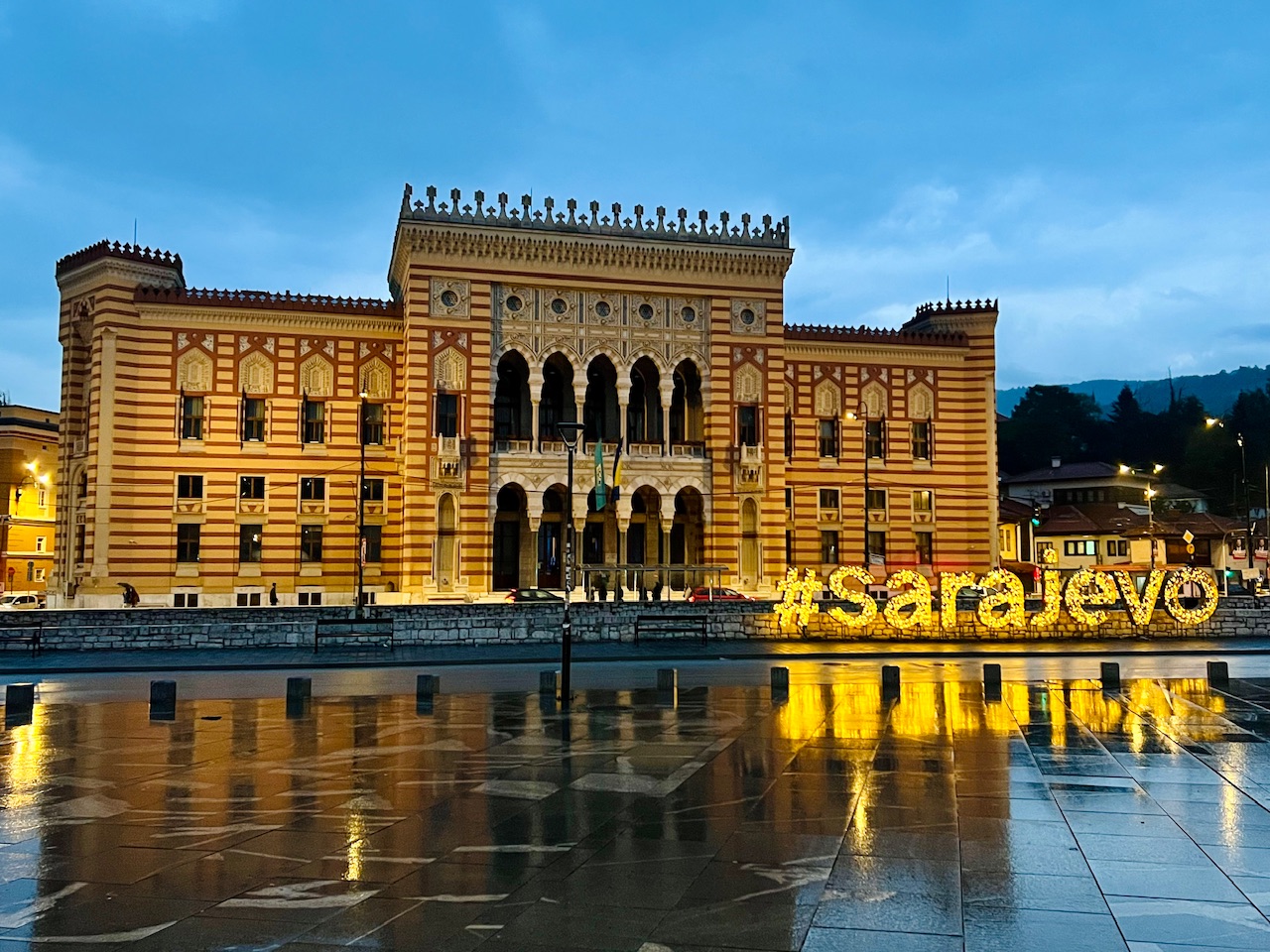 The Sarajevo City Hall and lighted Sarajevo sign reflected after a rainstorm