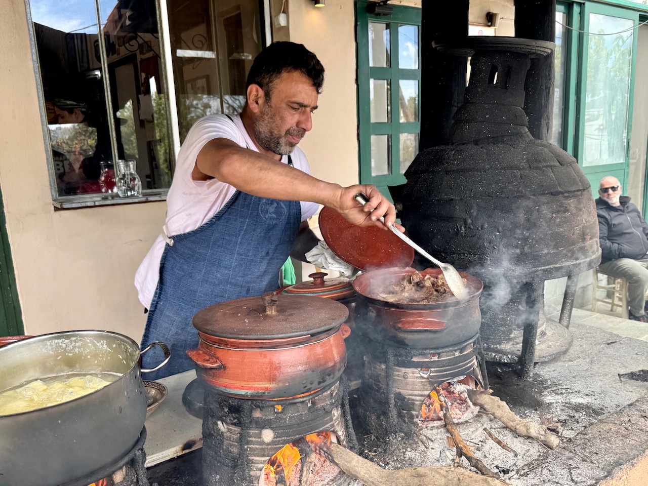 Chef Stelios tends to food cooking in traditional clay pots at Ntounias in Crete