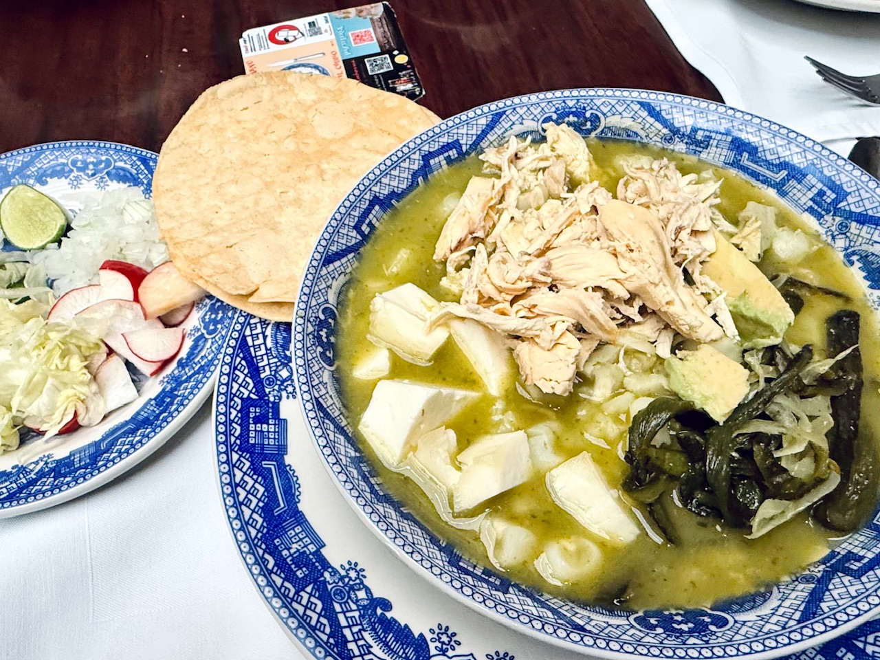The classic Mexico City food Pozole Verde with chicken, poblano peppers, avocado, and chunks of cheese from Casa de Los Azulejos in the heart of Mexico City