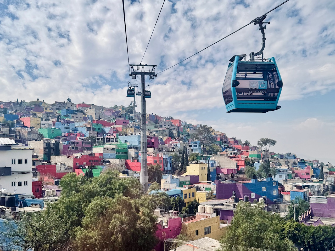 Cable Cars above colorful hilltop houses in Iztapalapa - touring Iztapalapa from the sky is one of the best things to do in Mexico City
