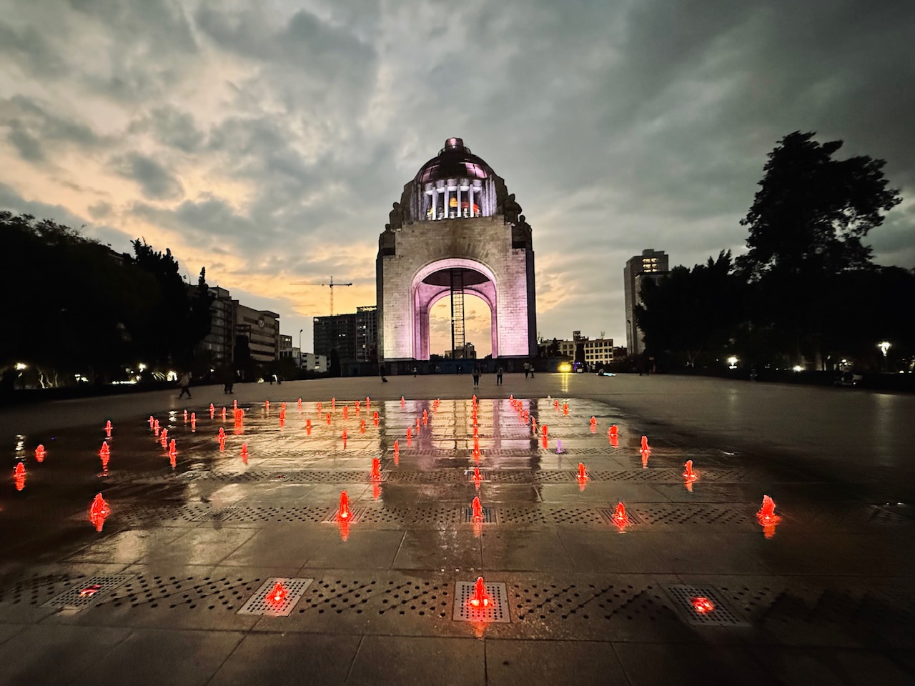 Mexico City's Monument to the Revolution at dusk with a reflection and red lights in a fountain