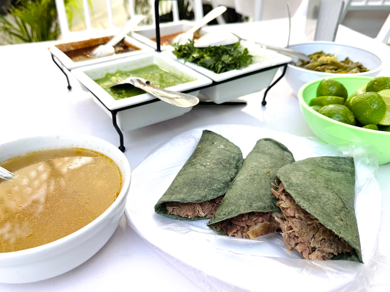 Barbacoa Tacos with a bowl of consommé and various salsas at Barbacoa Edison. These are some of the very best tacos in Mexico City