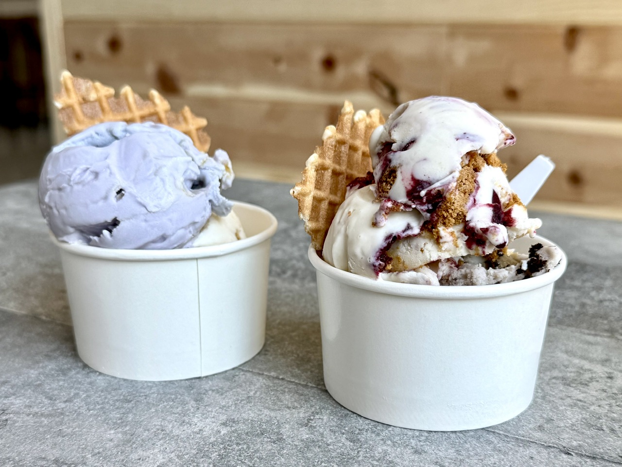 Two cups of ice cream in Salt Lake City at Blacksmith Ice Cream Company - including Honeybud and Berry Cheesecake flavors