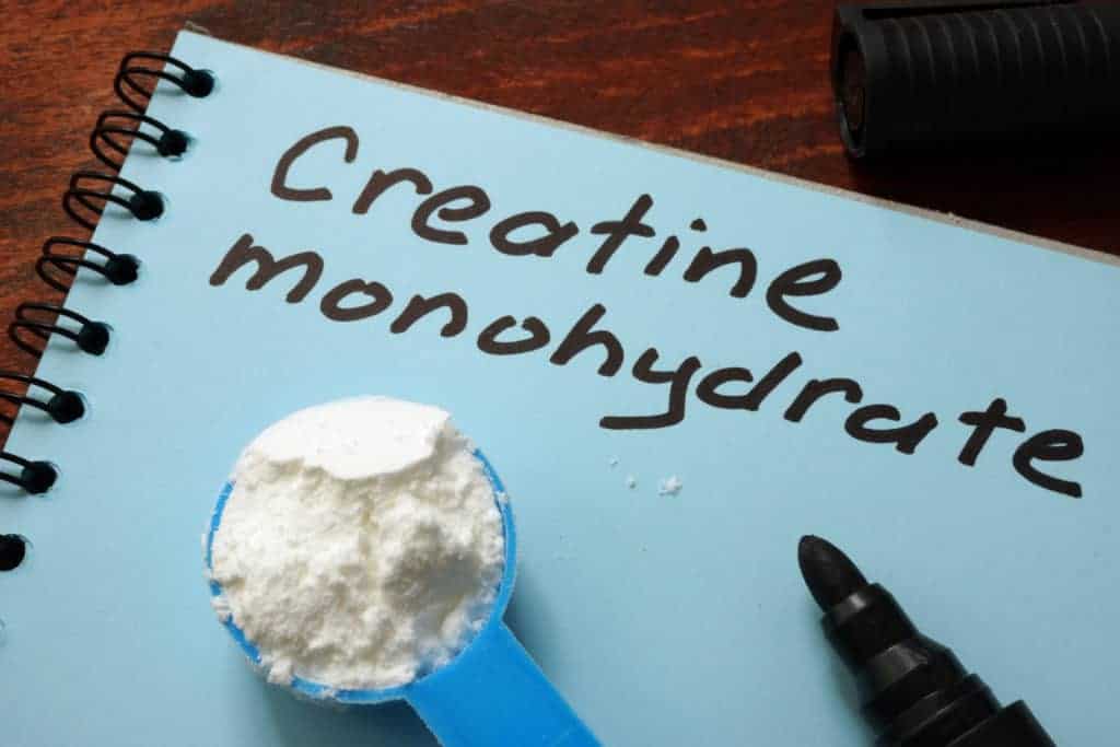 a textbook with creatine monohydrate powder on top of it