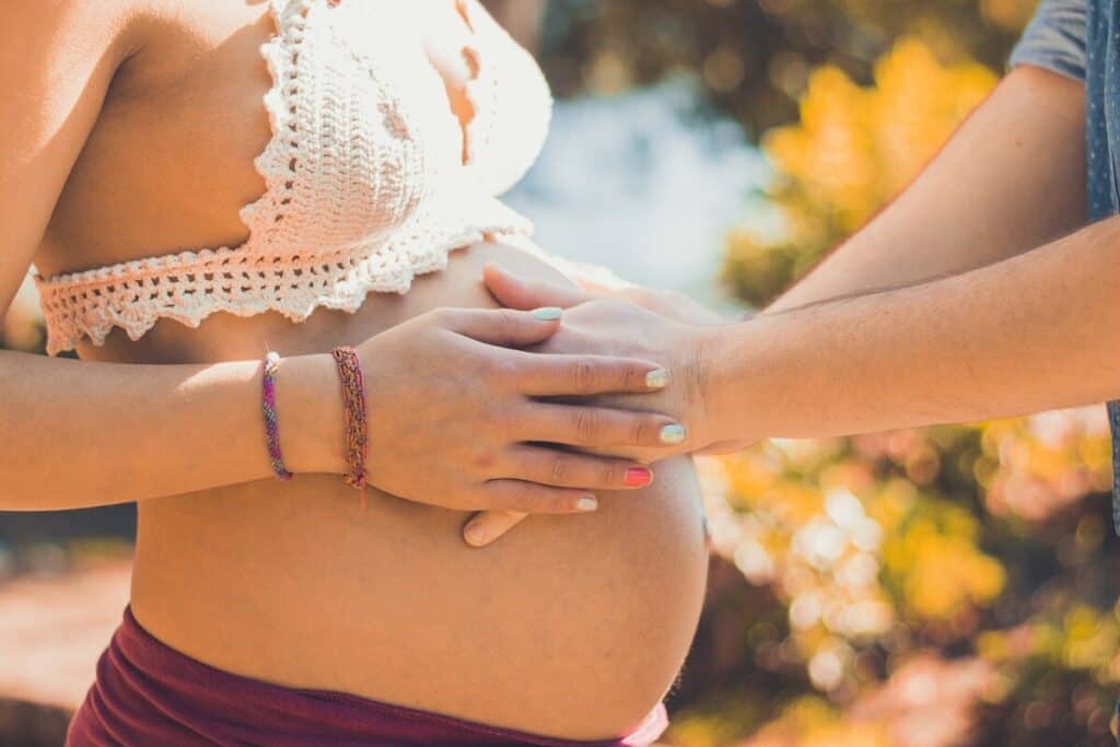 A man holding the belly of his pregnant wife