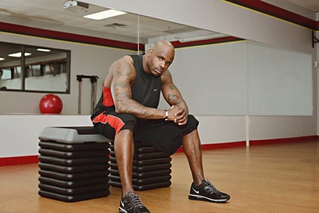 fit young black male sitting on a plyo box at the gym