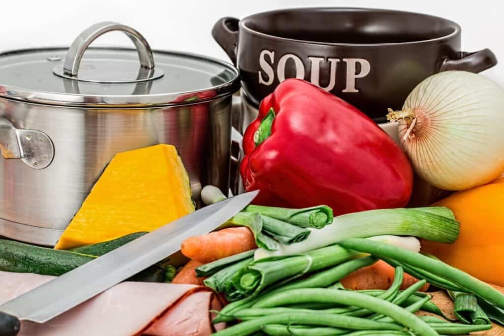 a pot for boiling soup with peppers, celery, hot peppers, onions and carrots to create a soup for a thermogenic diet meal plan