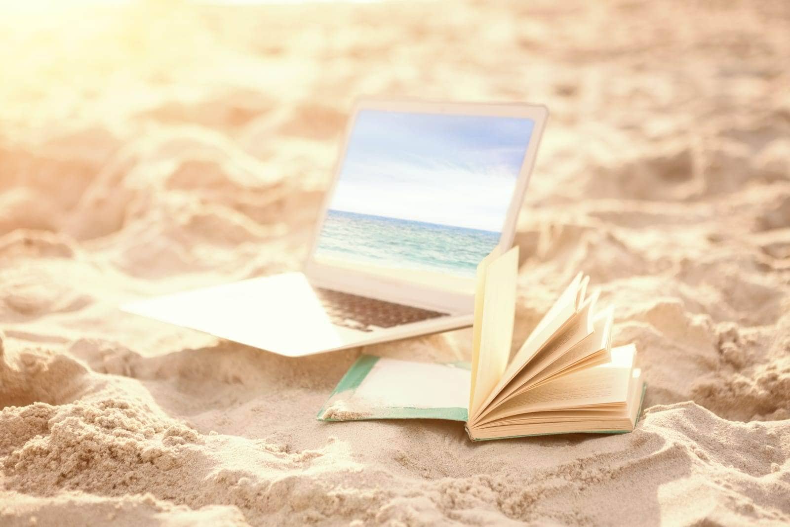 A laptop displaying educational content against the backdrop of a picturesque beach.