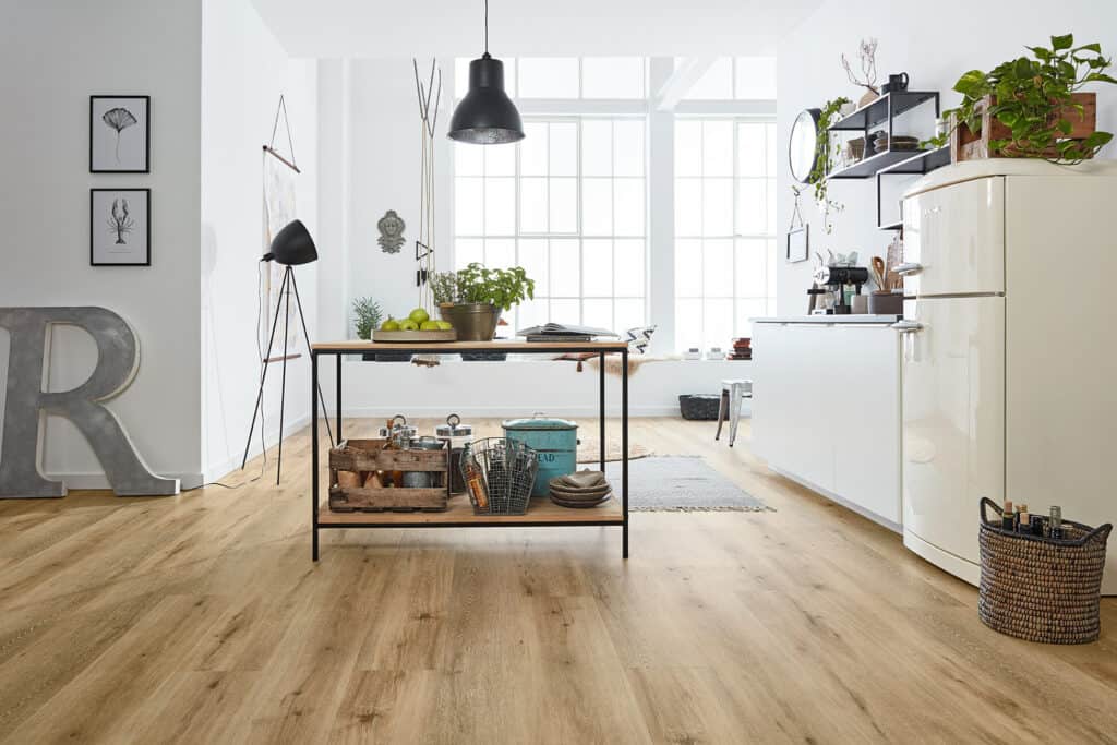 Offene Wohnsituation in der Küche mit einem werkhaus Bodenbelag in Holzdesign.