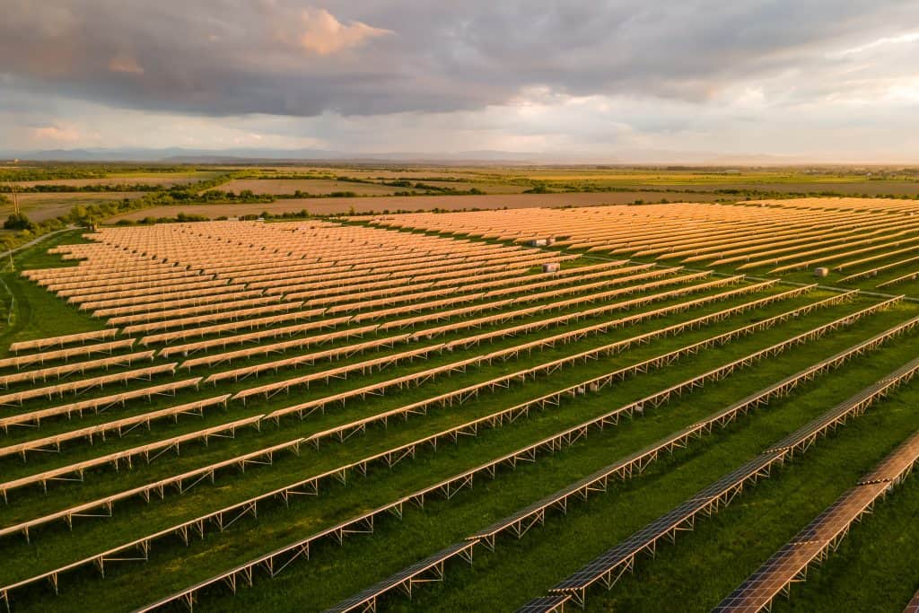 Aerial view of large sustainable electrical power plant with many rows of solar photovoltaic panels for producing clean ecological electric energy. Renewable electricity with zero emission concept.
