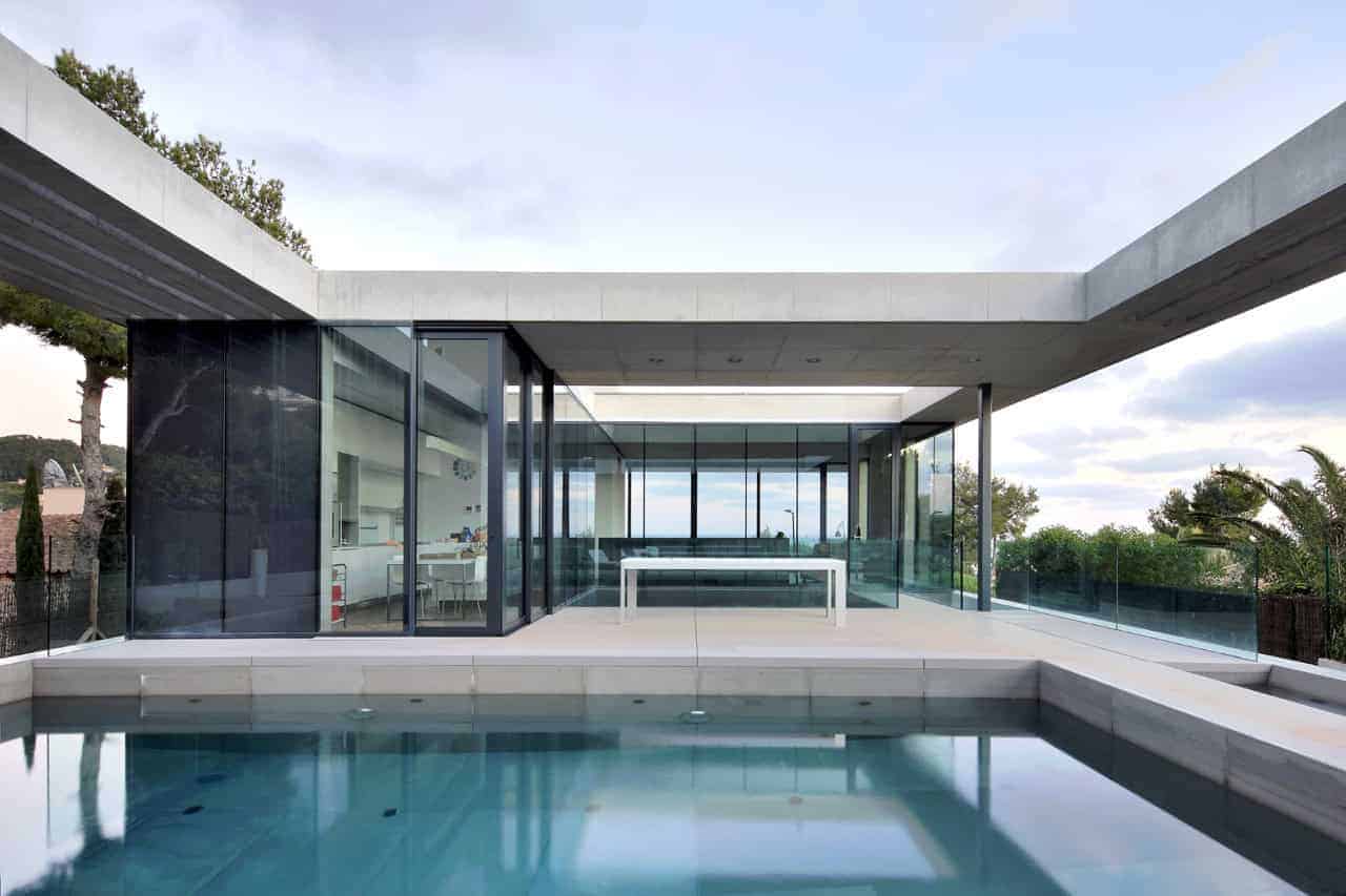 Modern architectural design with sleek glass walls and minimalist style, featuring an outdoor swimming pool and contemporary house architecture for luxury living.