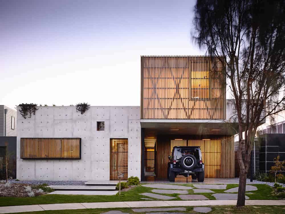 Sustainable modern house with concrete and wooden accents, minimalist landscaping, and a sleek exterior design showcasing innovative architecture.