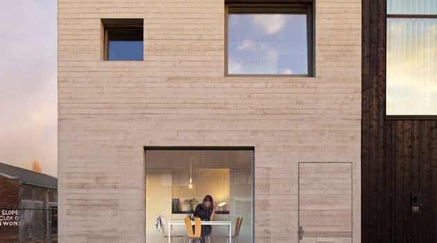 Modern minimalist house with large glass windows and wooden exterior, showcasing contemporary architecture and innovative design elements.