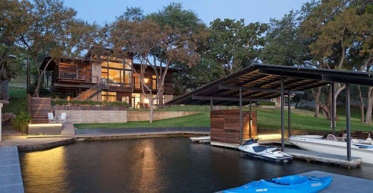 Modern lakeside house with boat dock, sleek wooden architecture, and scenic waterfront views emphasizing contemporary architecture, luxury home design, and outdoor living spaces.