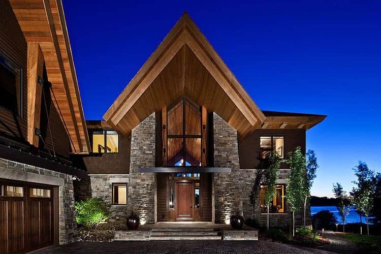 Luxury modern wood and stone residence with dramatic A-frame roof, featured in architectural design collections.