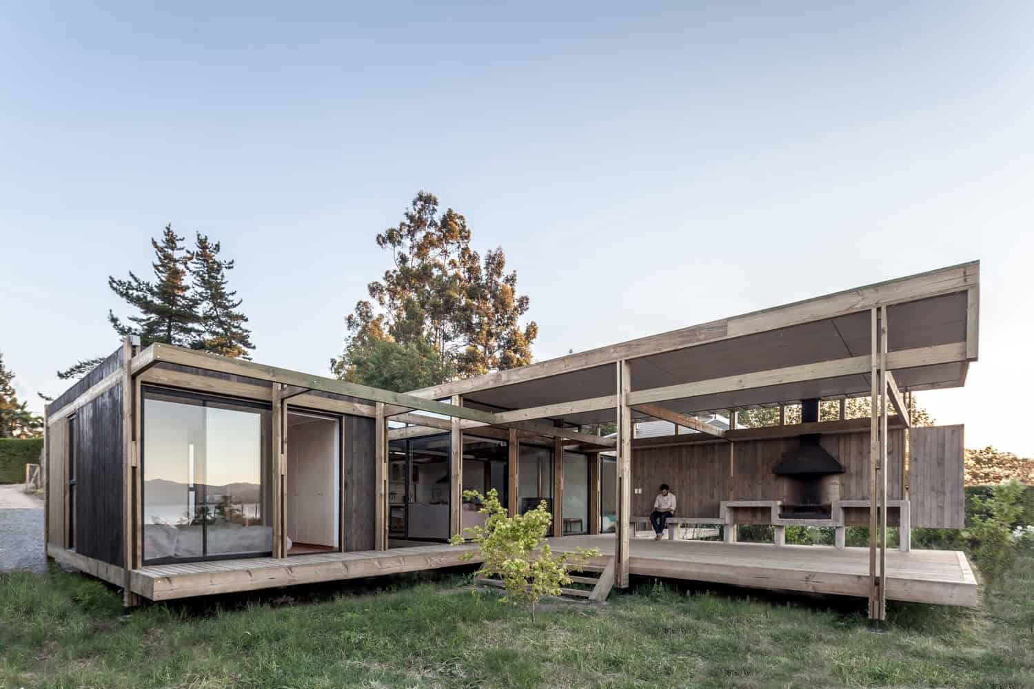 Sustainable modern wooden house with sleek architecture, large glass windows, and outdoor deck.