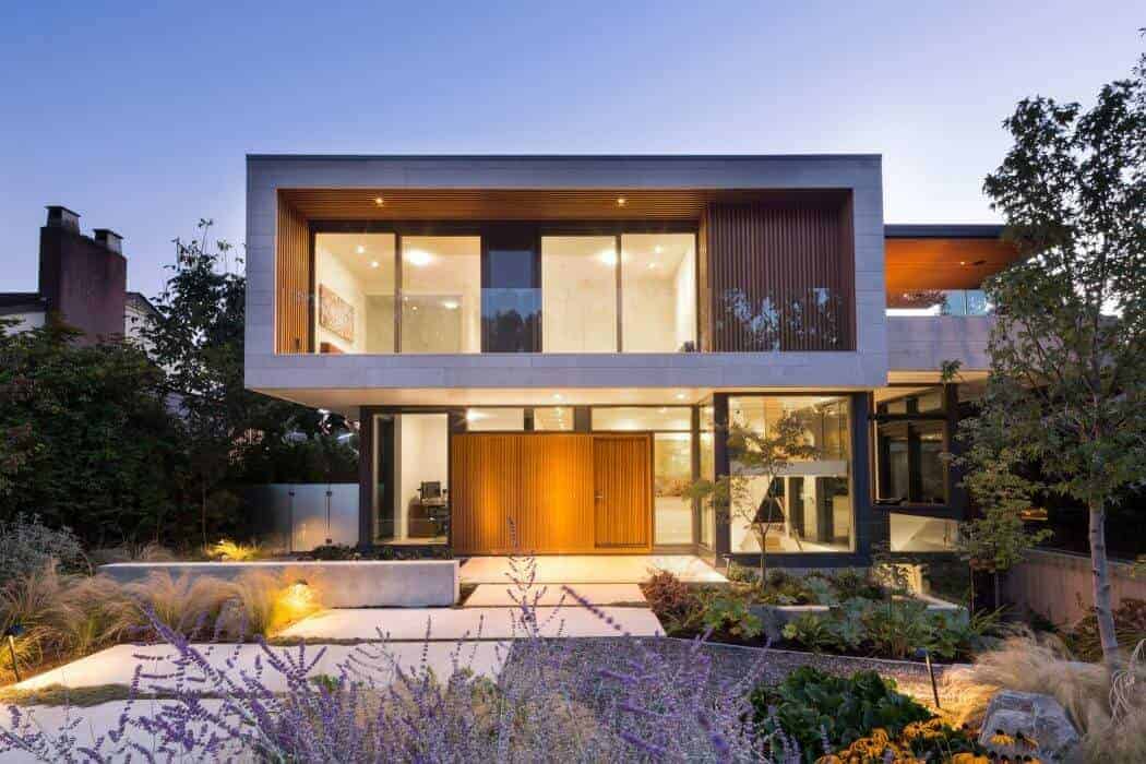 Modern luxury house exterior with contemporary architectural design, large glass windows, and sleek geometric shapes, surrounded by landscaped garden and outdoor lighting.