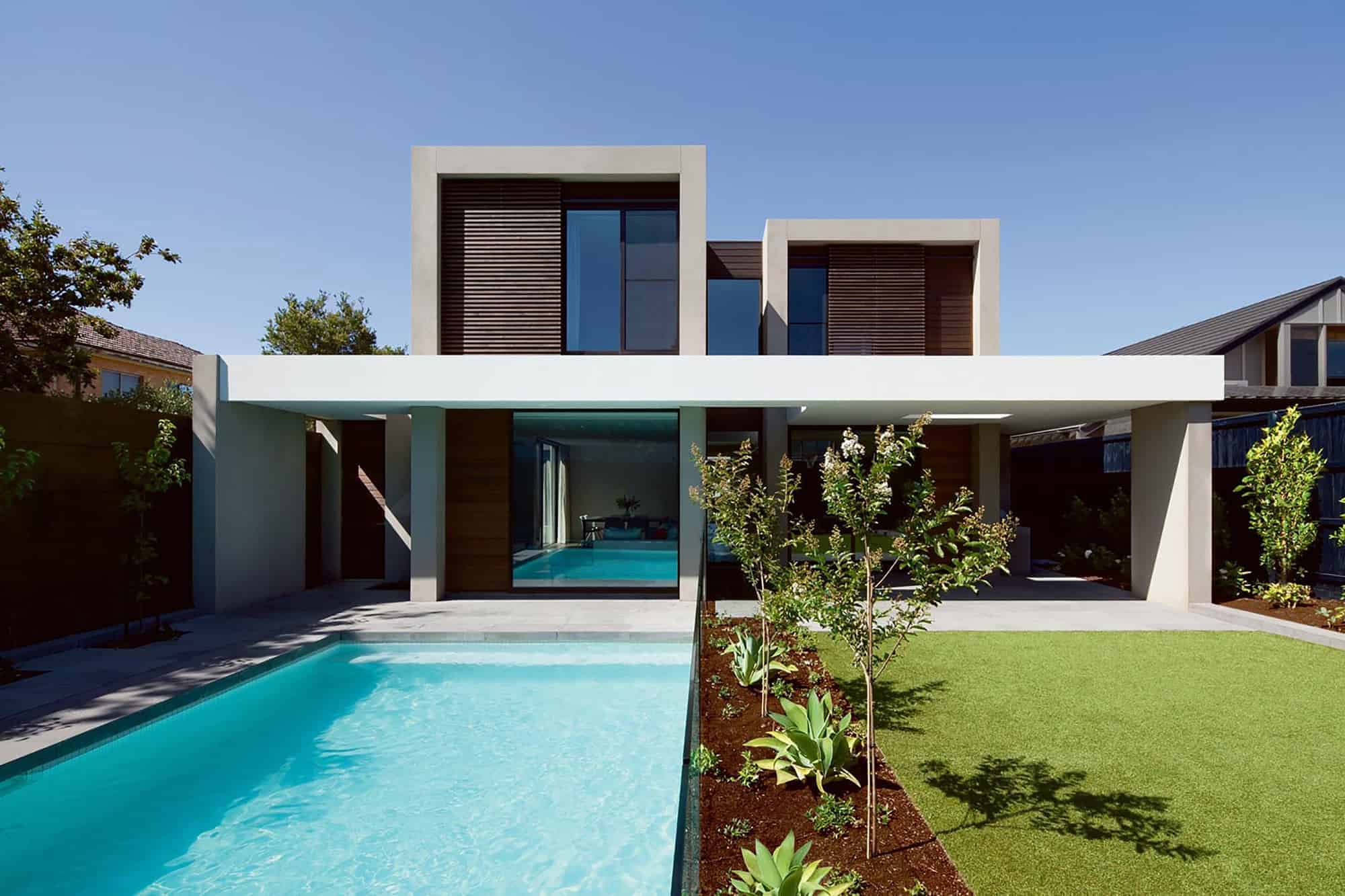 Modern luxury residence with contemporary architectural design and landscaped backyard featuring a swimming pool.