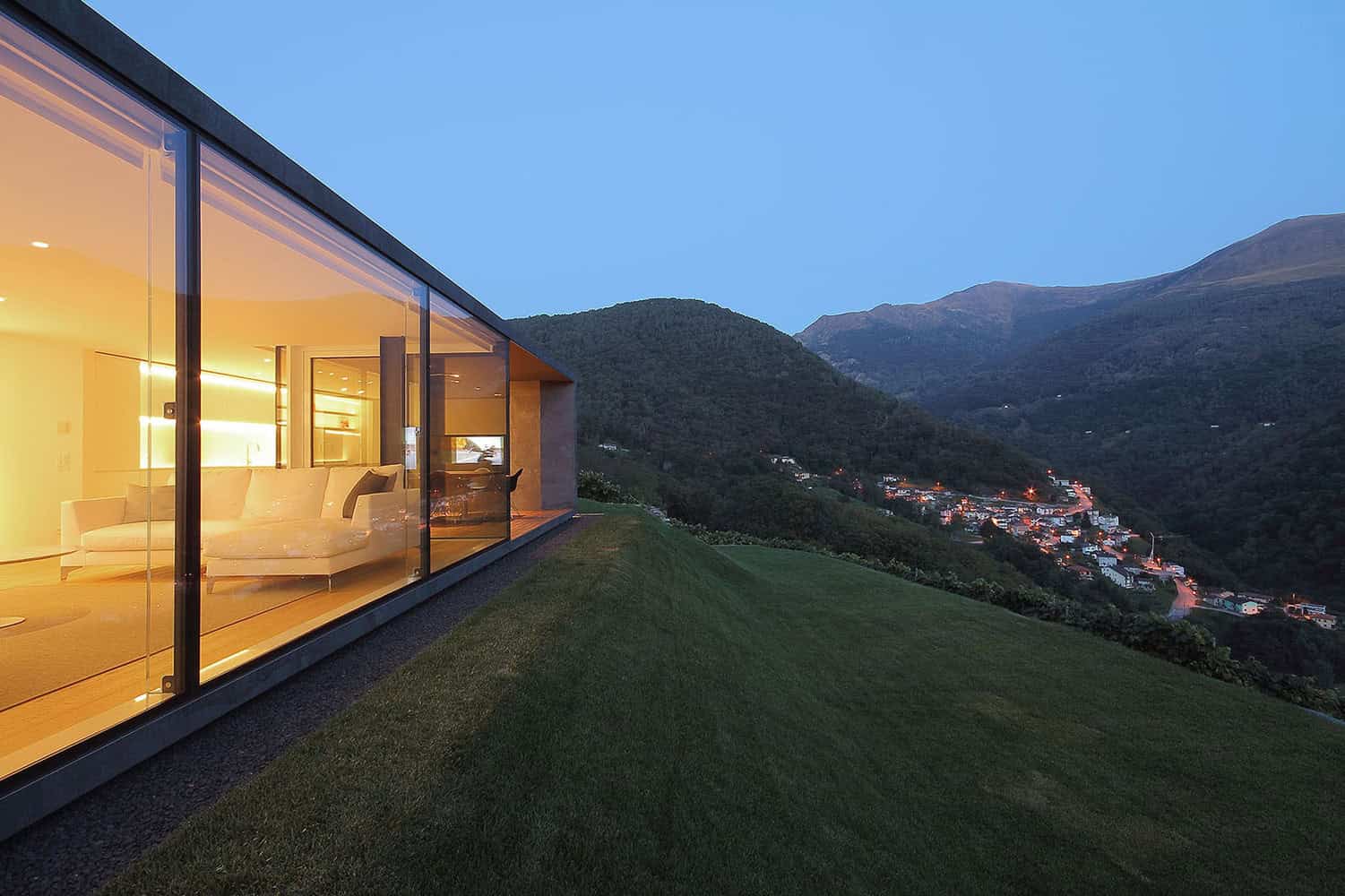 Contemporary glass house with stunning mountain views, minimalist architecture, and modern design features. Perfect example of innovative architecture and luxury home aesthetics.