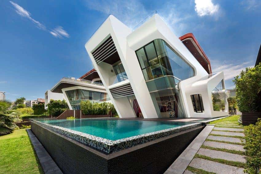 Futuristic modern house with angular white architectural design, glass walls, and swimming pool, showcasing innovative architecture and contemporary home design.