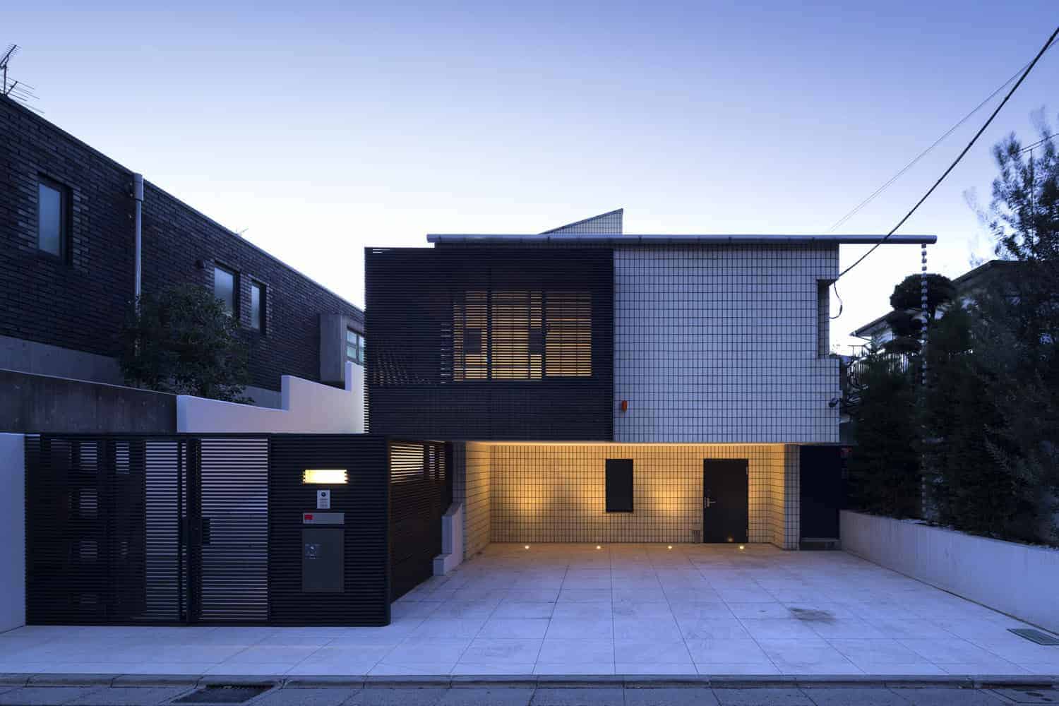 Sleek modern house with black and white tiled exterior, innovative architectural design, and ambient lighting showcasing contemporary architecture and stylish home design.