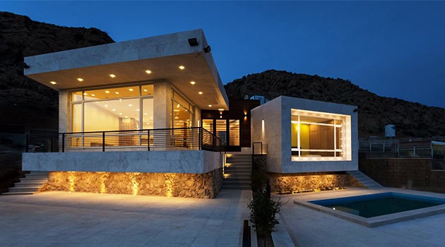 Contemporary modern house with sleek architectural design, large glass windows, and outdoor pool at dusk, highlighting luxury residential architecture.