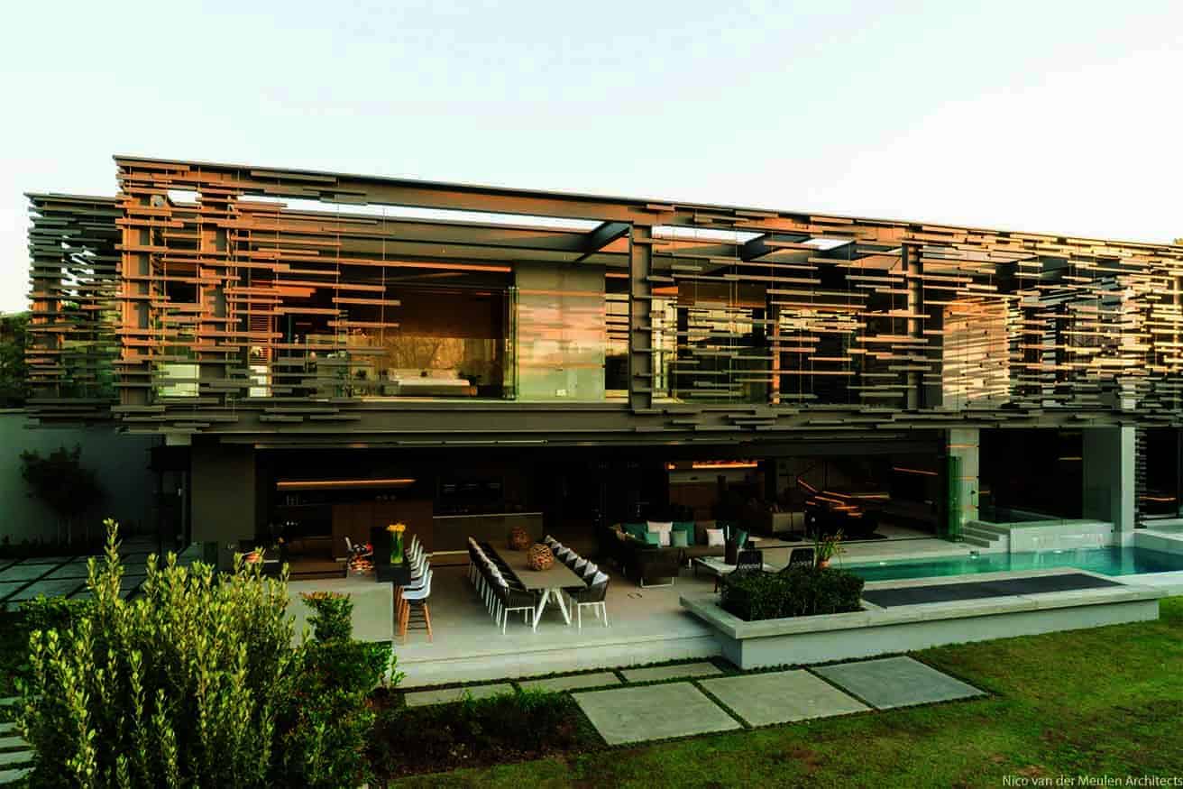 Contemporary modern architectural house with innovative geometric design, wooden slat facade, open living spaces, outdoor pool, and lush landscaping, exemplifying cutting-edge architecture art and design.