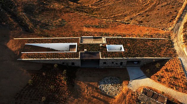 Modern minimalist concrete house with rooftop gardens and scenic landscape views, showcasing innovative architecture and sustainable design principles.