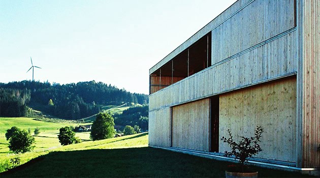 Modern minimalist architecture with sustainable wooden design and scenic countryside views.