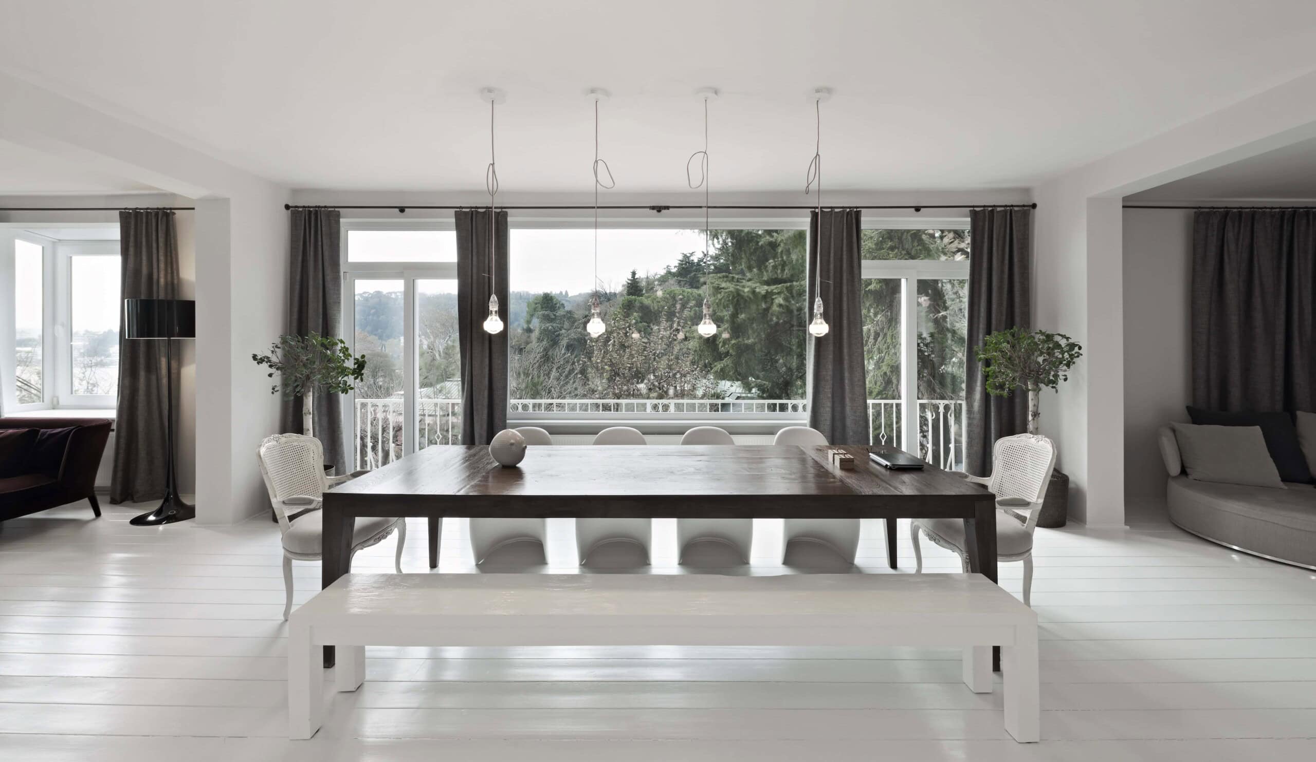 Spacious modern dining room with large windows, minimalist decor, and natural light, showcasing contemporary architecture and stylish interior design elements.