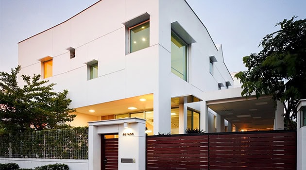 Modern white architectural house with minimalist design, large windows, and sleek lines, showcasing contemporary residential architecture.