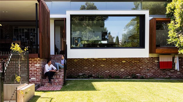 Modern contemporary house with large glass window and brick exterior showcasing innovative residential architecture and stylish design.