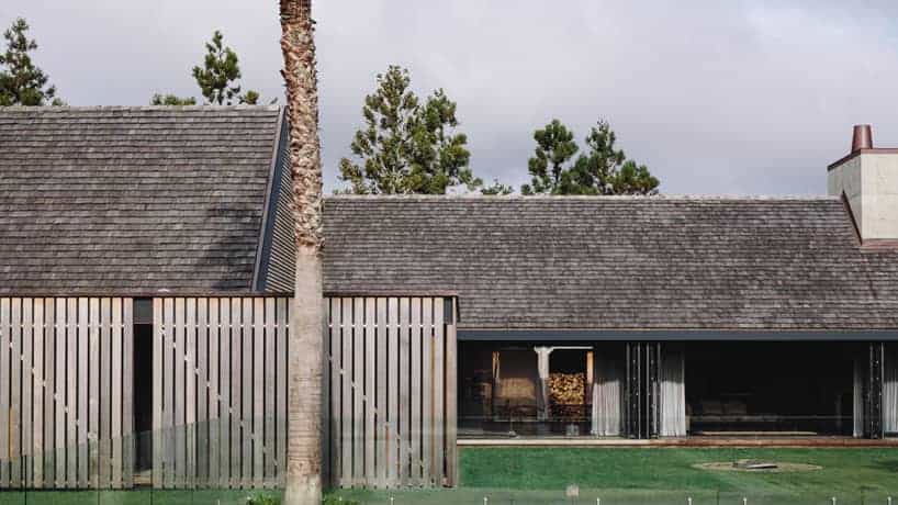 Modern residential home with contemporary architecture, featuring clean lines, wooden slat fencing, and natural materials. Perfect example of blending indoor and outdoor living spaces.