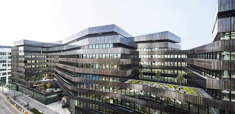 Modern architectural office building with sleek glass facade and unique layered design, exemplifying contemporary architecture and innovative design concepts.